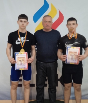 AntrenorulOleg Cucoș împreună cu campionii Denis Dînga și Nichita Cojocaru